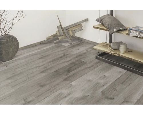 Světlá místnost s šedou dřevěnou podlahou, dekoracemi a regálem