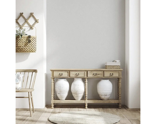 Světlý pokoj s dřevěnou konzolou, vázami a dekoracemi pro příjemnou atmosféru.