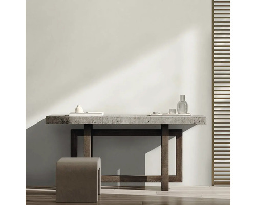 Světlá místnost s minimalistickým designem, která se skládá ze stolu, stoličky a dekorativních předmětů.