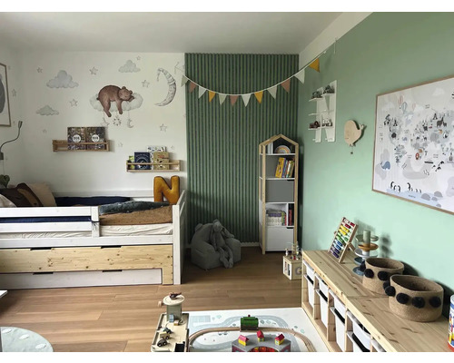 Světlý dětský pokoj s postelí, knihovnou, hračkami a nástěnnou dekorací