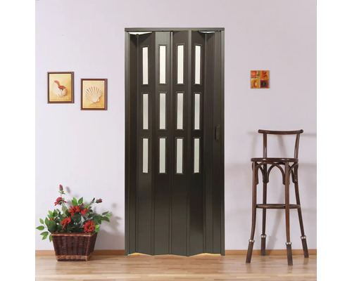 Tmavě hnědé skládací dveře s okenními panely před zdí