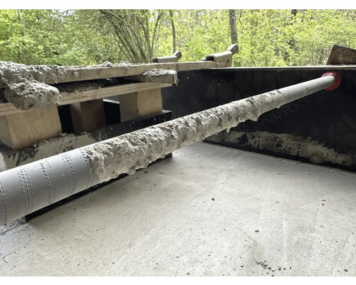 Betonová trubka se zbytky betonu na staveništi