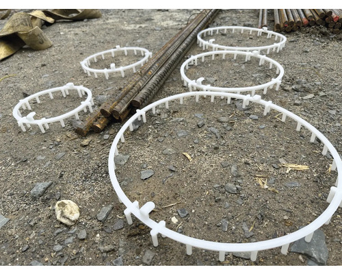 Několik plastových distančních prvků pro výztužné koše na staveništi