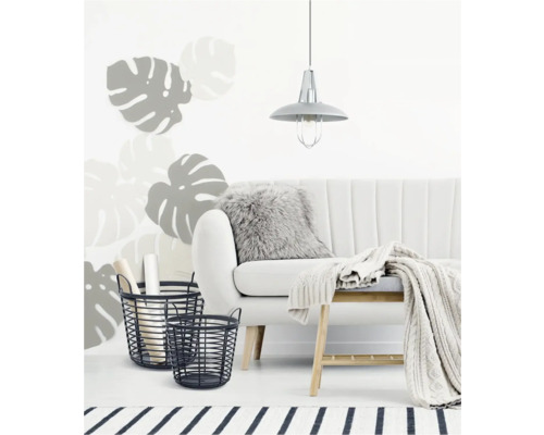 Světlý obývací pokoj s pohovkou, stropní lampou, dvěma drátěnými košíky, polštářem a vlněnou dekou