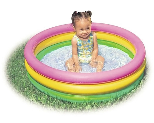 Dítě sedí v nafukovacím brouzdališti na zahradě.