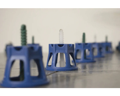 Modré montážní nožky se stavěcími šrouby na podlaze