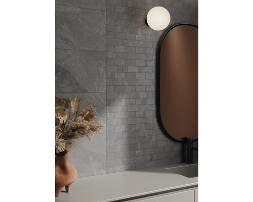 Koupelna s šedými obklady, zrcadlem a lampou