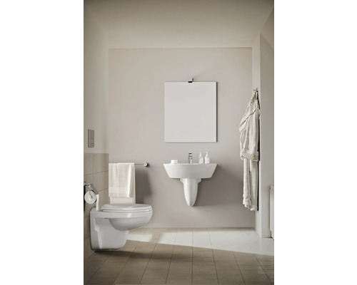 Světlá koupelna s toaletou, umyvadlem a zrcadlem