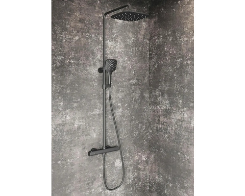 Černá sprchová armatura s hlavovou a ruční sprchou před šedou stěnou