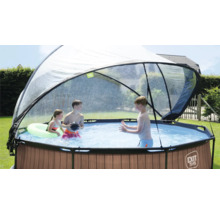 Kulatý bazén s krytem a hrajícími si dětmi na zahradě.