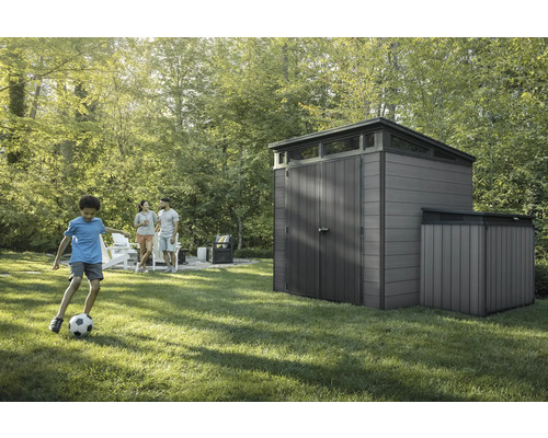 Zahradní scéna s kůlnou na nářadí a rodinou na trávníku