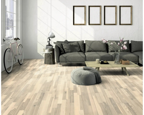 Světlý obývací pokoj s dřevěnou podlahou, pohovkou a dekorativními prvky pro útulnou atmosféru.