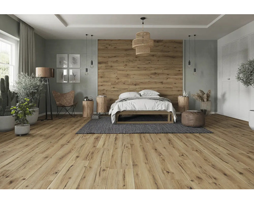 Světlá ložnice s dřevěnou podlahou, postelí, dekorací a přírodními prvky pro přátelskou atmosféru.