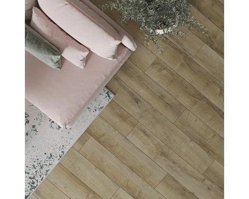 Pohled na pokoj s dřevěnou podlahou, pohovkou, polštáři a rostlinou