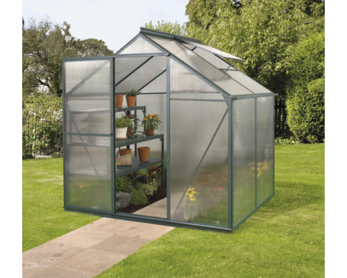 Skleník s regály a rostlinami na zahradě