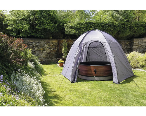 Venkovní scéna se stanem a vířivkou na zahradě.