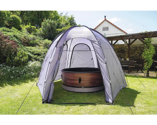 Venkovní scéna s koupacím sudem pod kopulovitým stanem na zahradě.