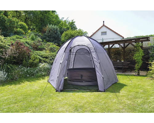 Venkovní scéna s vířivkovým stanem postaveným na zahradě