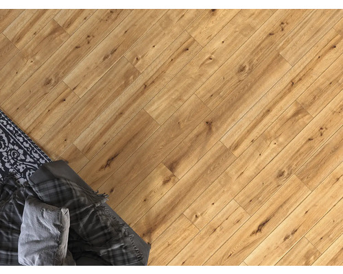 Pokládka laminátové podlahy v obývacím pokoji s kobercem a dekou.