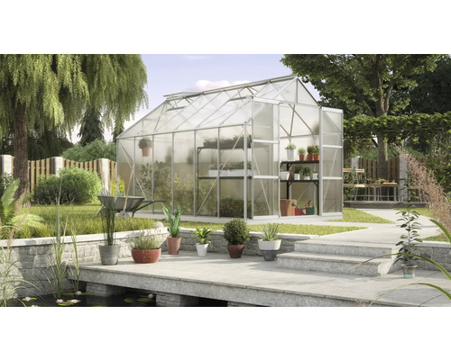 Skleník v zahradě s policemi na rostliny a jezírkem