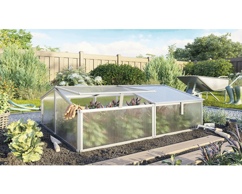 Skleník v zahradě s zahradním nářadím a kolečkem