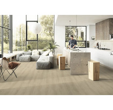 Světlý, otevřený obývací pokoj s dřevěnou podlahou, šedou pohovkou a kuchyňským ostrůvkem