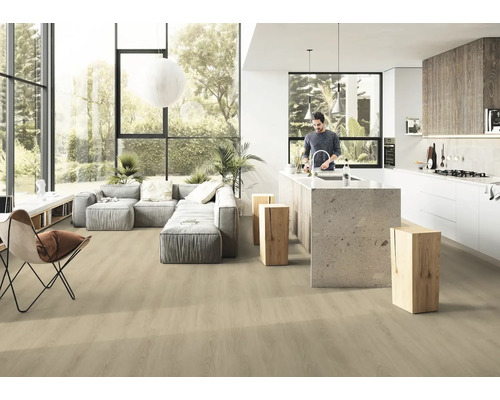 Světlý, otevřený obývací pokoj s dřevěnou podlahou, šedou pohovkou a kuchyňským ostrůvkem