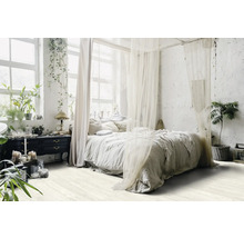 Světlá ložnice s nebesy, rostlinami a komodou