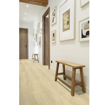 Chodba s dřevěnou podlahou, dřevěnými lavicemi a zarámovanými obrazy na zdi