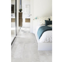 Světlá ložnice s koupelnou a odpovídajícími dlaždicemi.