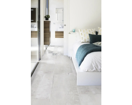 Světlá ložnice s koupelnou a odpovídajícími dlaždicemi.