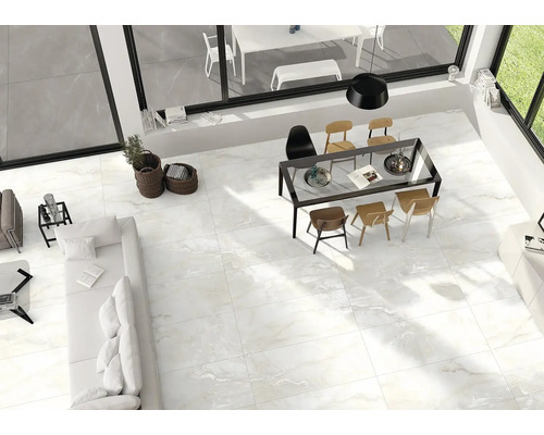 Světlý obývací pokoj s dlažbou, jídelním stolem a posezením.