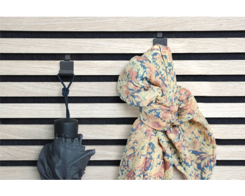 Nástěnný panel s háčky, na kterých visí deštník a šála