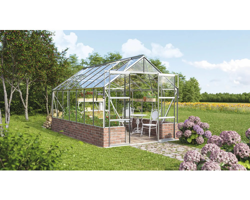 Skleník s policemi, stolem a židlemi na zahradě