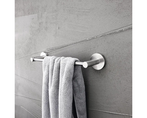 Nerezový držák na ručníky s ručníkem na šedé zdi