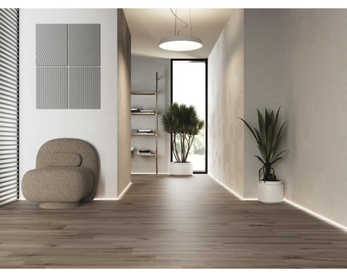 Světlý interiér s akustickými panely, křeslem a hrnkovými rostlinami na dřevěné podlaze.