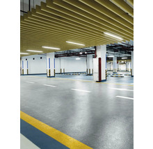 Interiérová fotografie podzemní garáže s betonovou podlahou, sloupy a stropním obkladem.