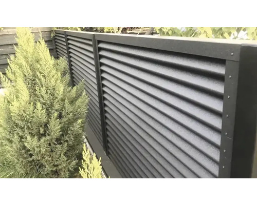 Pohled na plot s lamelovou strukturou na zahradě