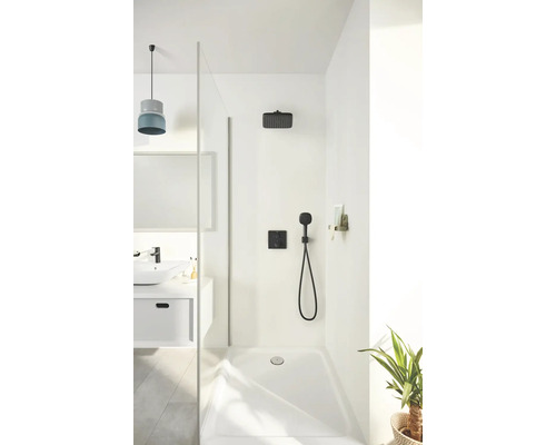 Sprchový kout se sprchovou hlavicí, ruční sprchou a sprchovou vaničkou ve světlé koupelně