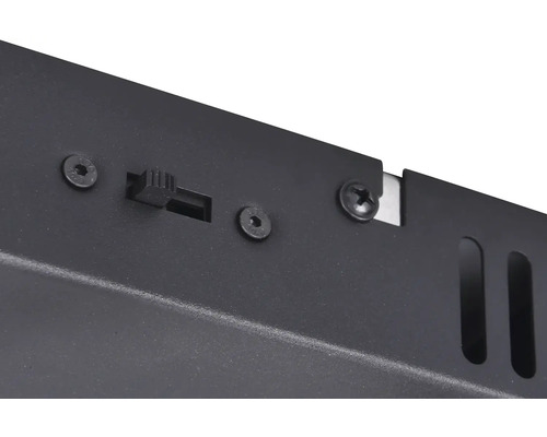 Detailní záběr spínače a šroubů na černé kovové skříni.