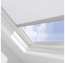 Detail střešního okna s výhledem na modrou oblohu.