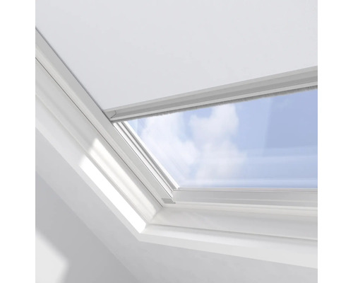 Detail střešního okna s výhledem na modrou oblohu.