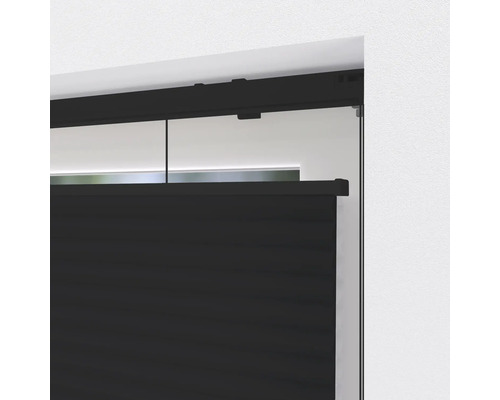 Detailní pohled na černé plisované žaluzie na okně