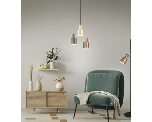 Obývací pokoj s křeslem, komodou, závěsnými svítidly a stojací lampou pro světlou a příjemnou atmosféru