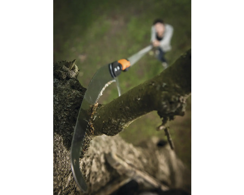 Prořezávací pila řeže větev stromu na zahradě