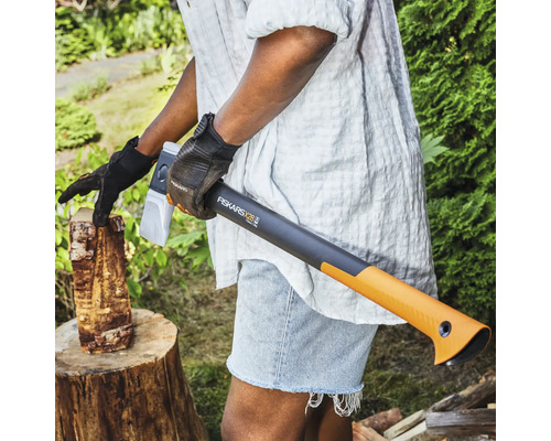 Osoba štípá dřevo pomocí štípací sekery Fiskars X28