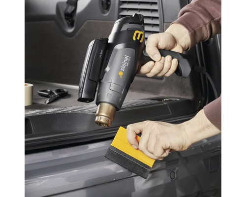 Horkovzdušná pistole se používá k nanášení fólie pomocí stěrky.