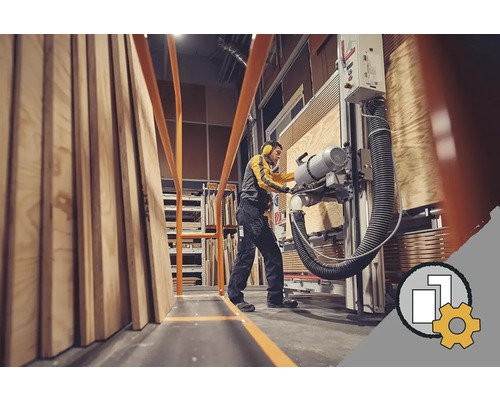 Zaměstnanec řeže dřevěné desky na formátovací pile ve skladu.