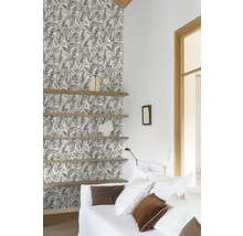 Obývací pokoj s tapetou se vzorem, dřevěnými policemi a bílou pohovkou.