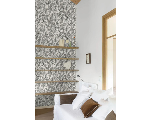 Obývací pokoj s tapetou se vzorem, dřevěnými policemi a bílou pohovkou.